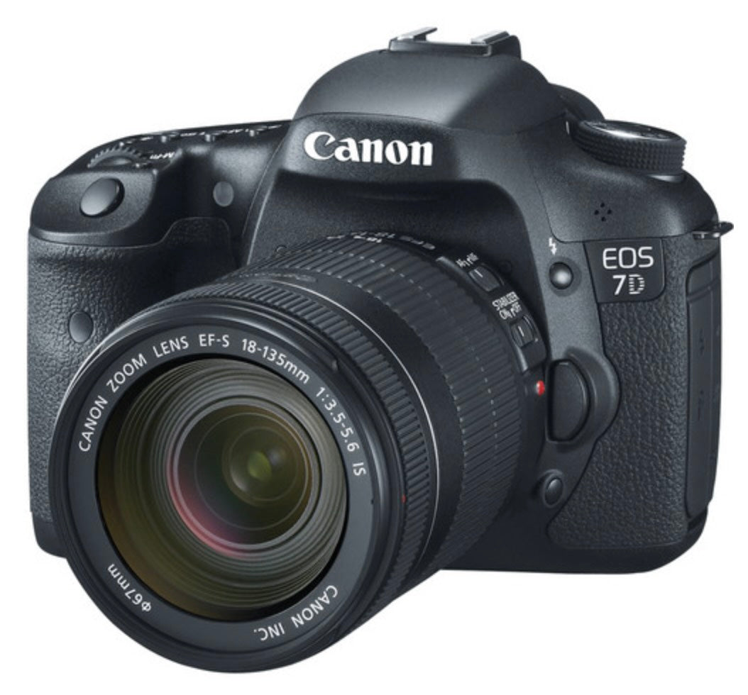 Front view of a Canon EOS 7D digital camera body with 18-135mm Canon lens with lens cap off