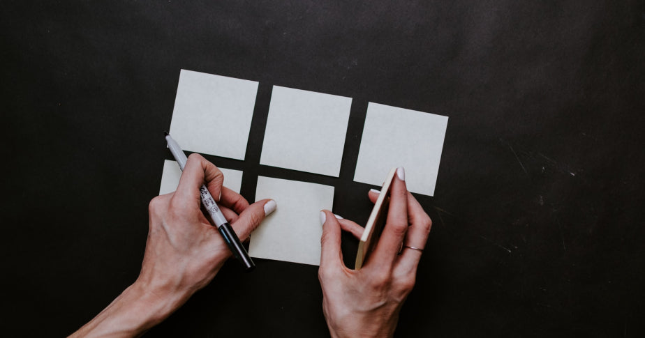 Mulher colocando post-its na mesa para planejamento