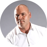 Headshot of Michael Henderson, Founder, WOLFPak, sitting on a chair.