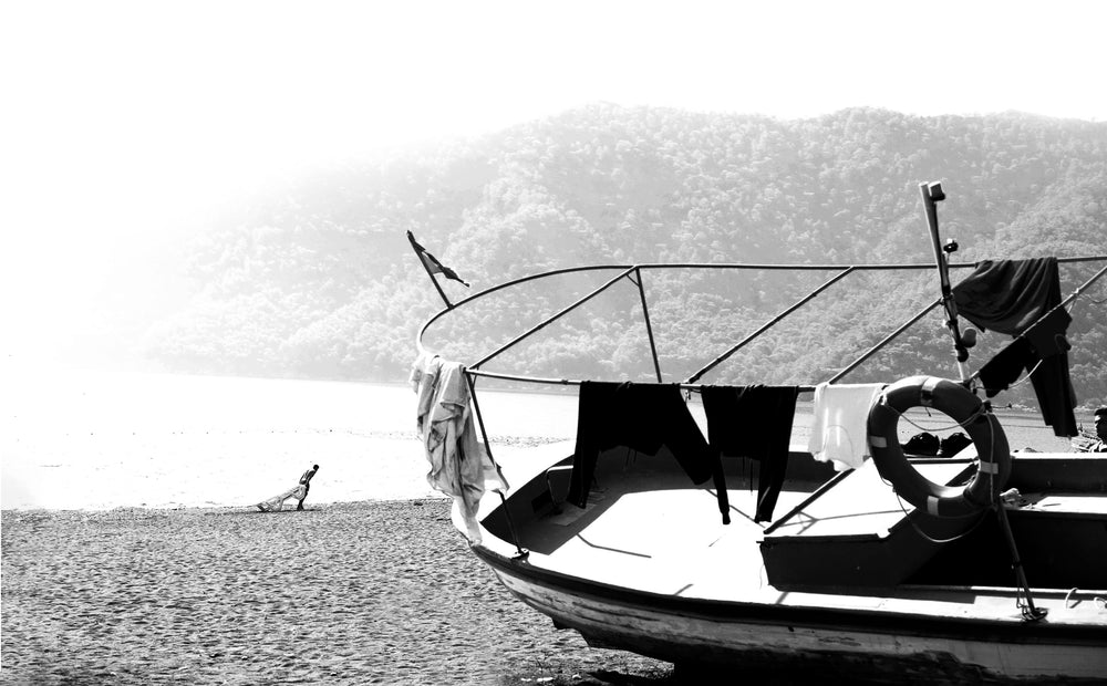 a boat with clothing on it on the shore