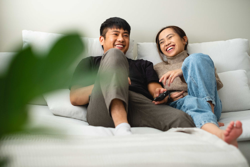 a couple laughing and relaxing together on their couch