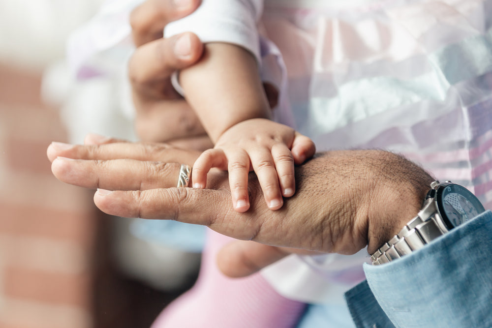 baby girls hand on dads hand