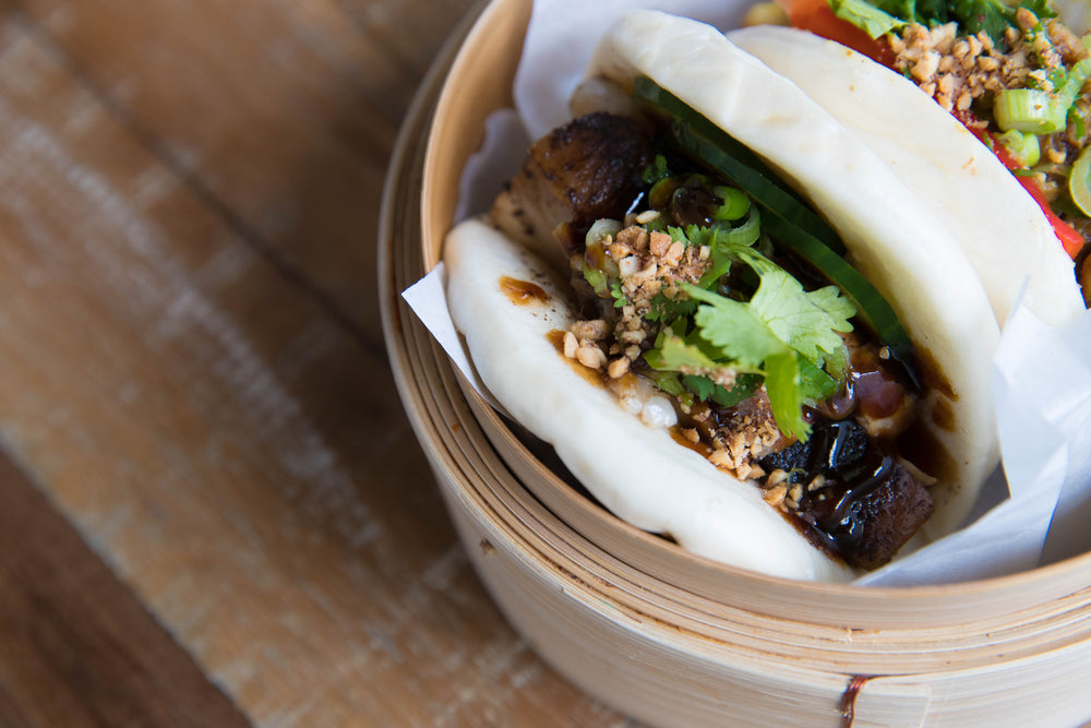 close up of a bao bun on a wooden table