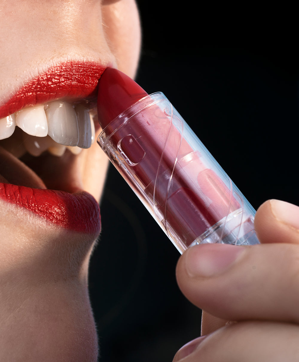 close up of person applying red lipstick