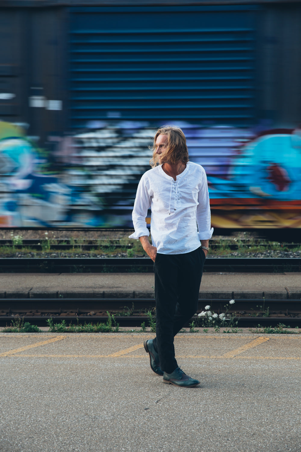 fashionable man walks by train tracks