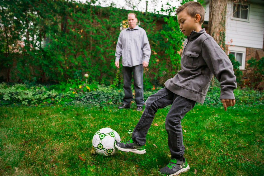 father and son playing soccer