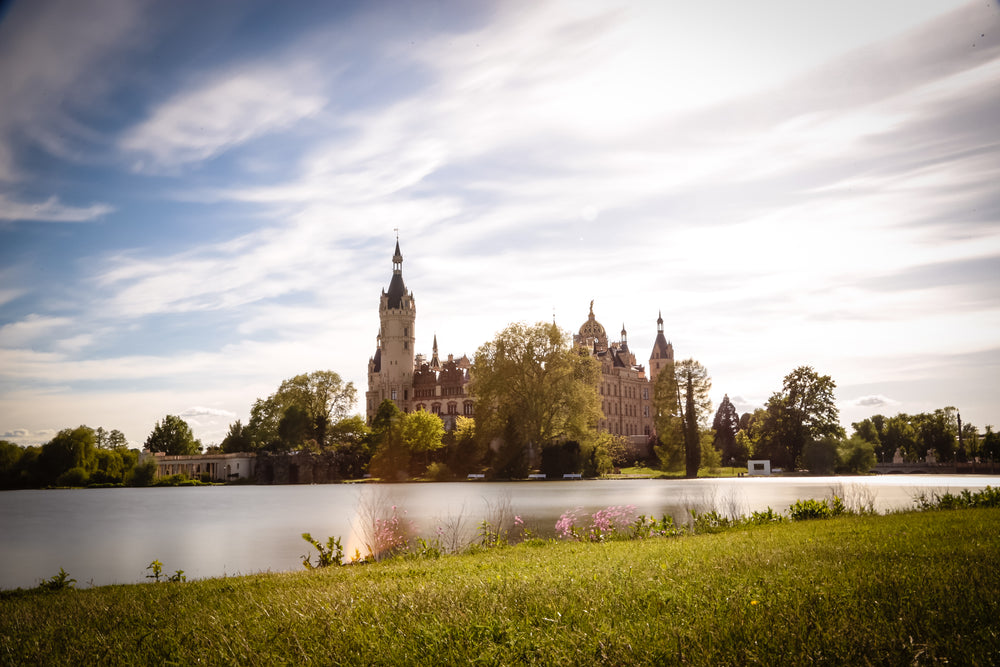 green grass by a lake and castle