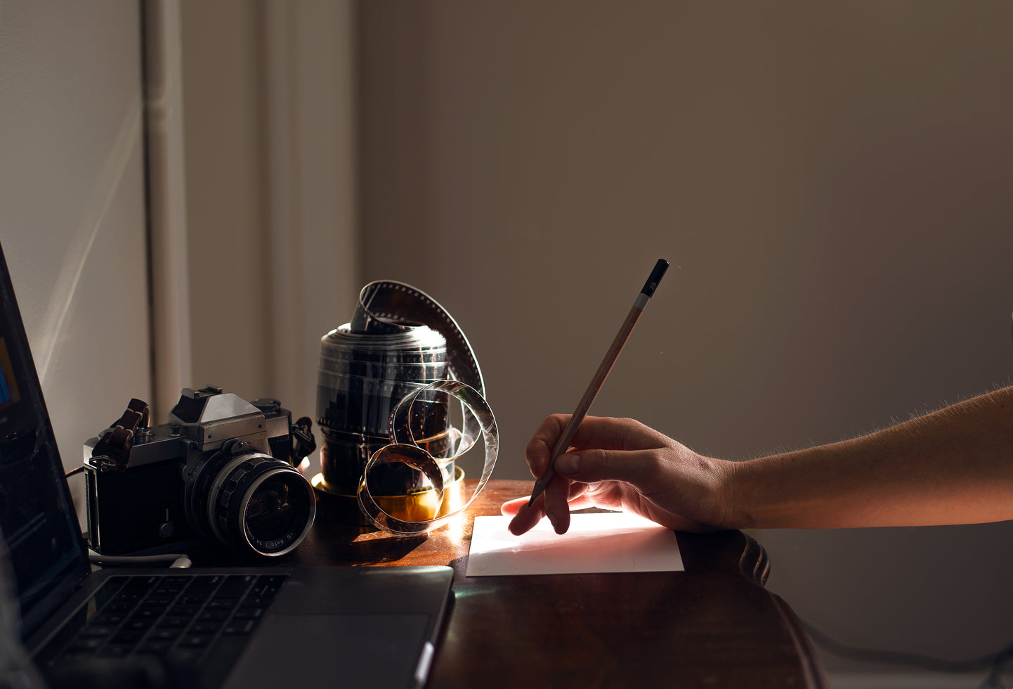 hand holds a pencil ready to write at a desk