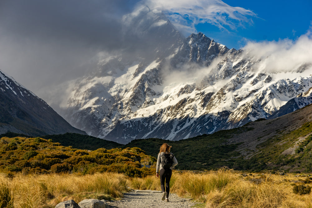 hiker approaches snow-capped mountains