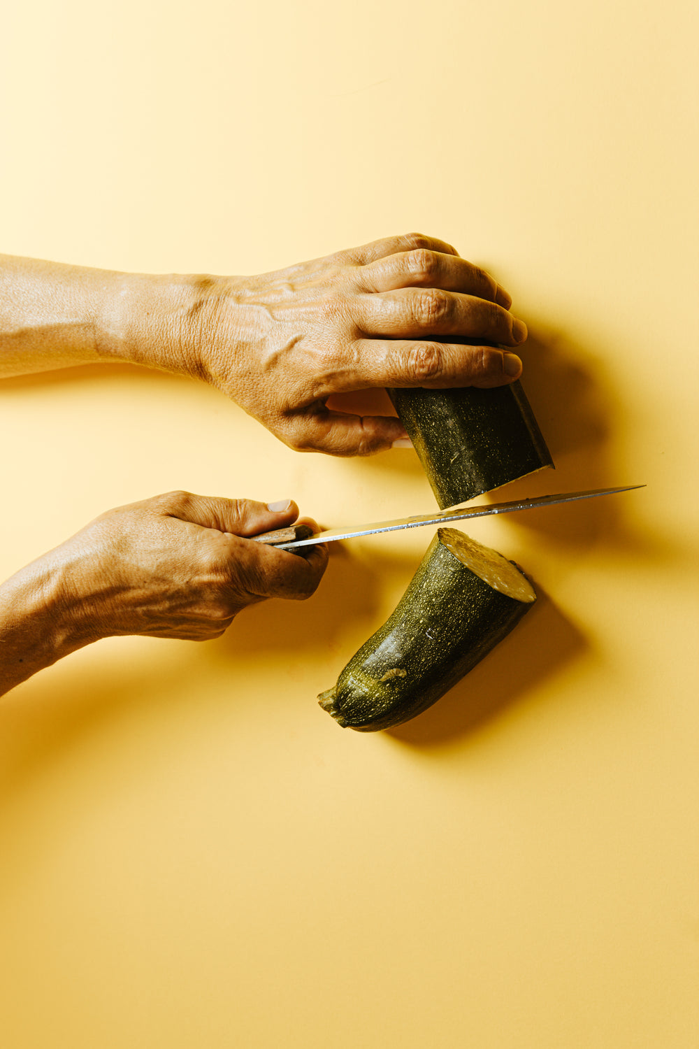 knife slices a zucchini in half