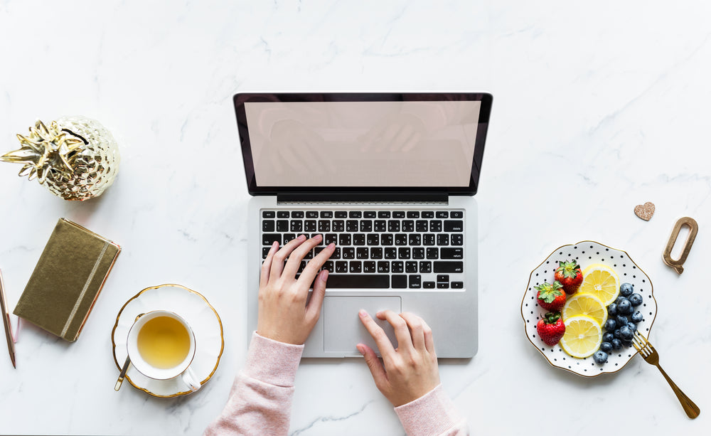 laptop at the table with tea at side