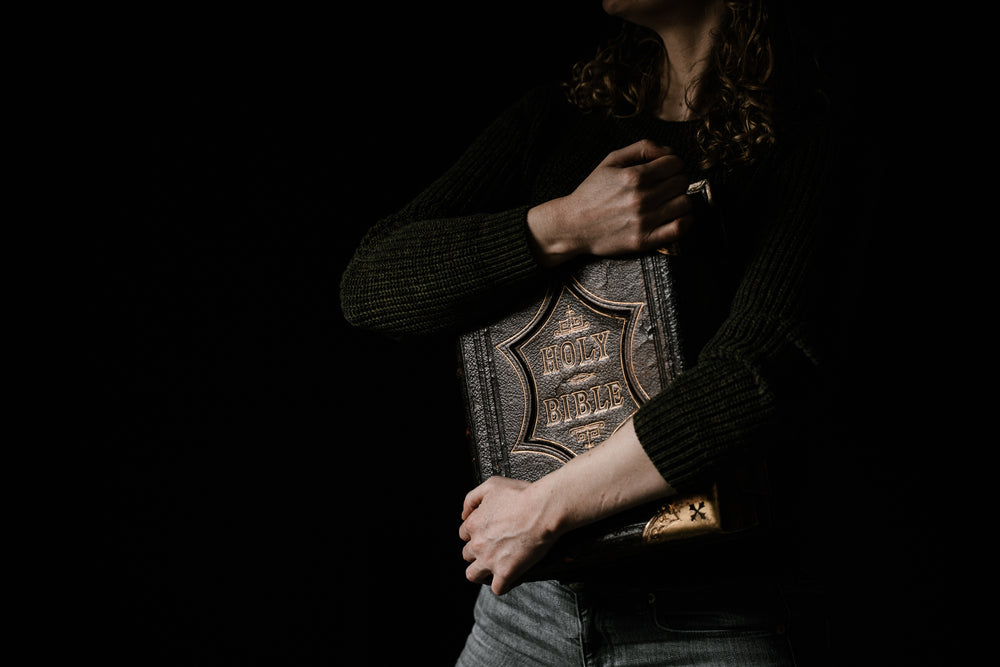 large bible held to  chest