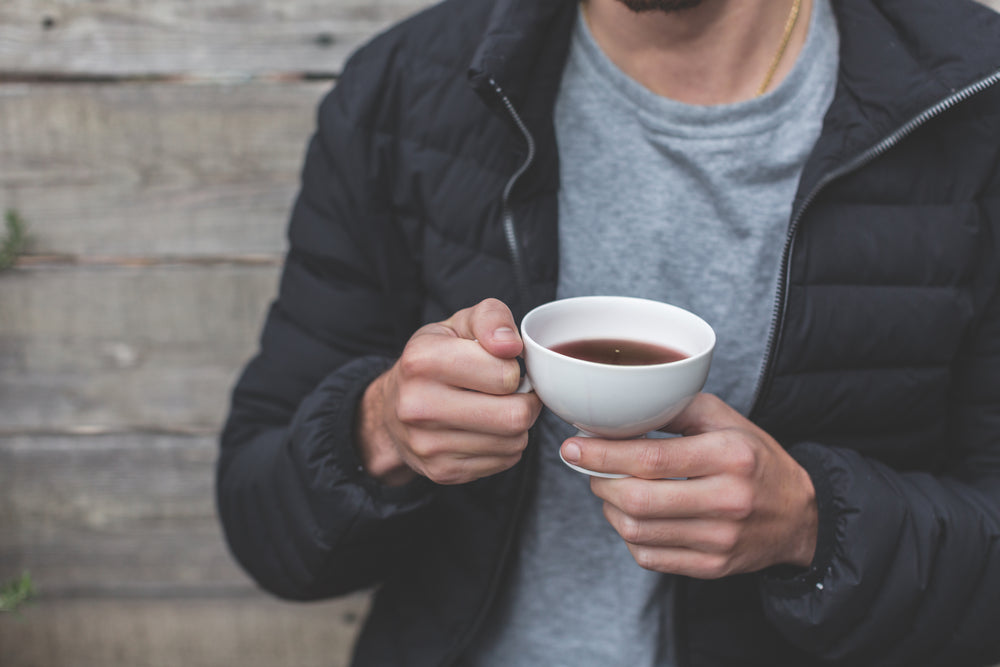 man holding cup of tea