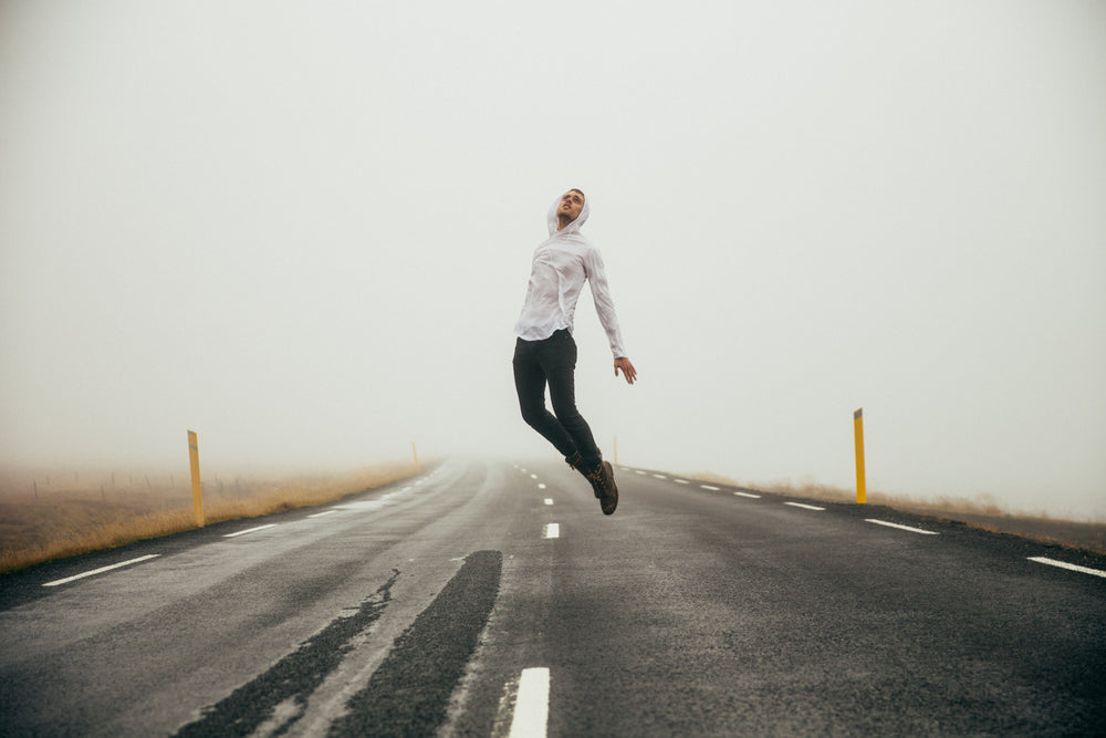 man jumping over highway