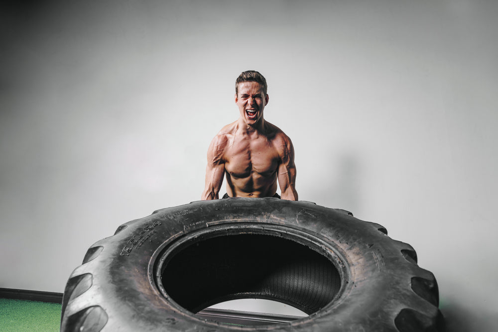 man lifts tire exercise