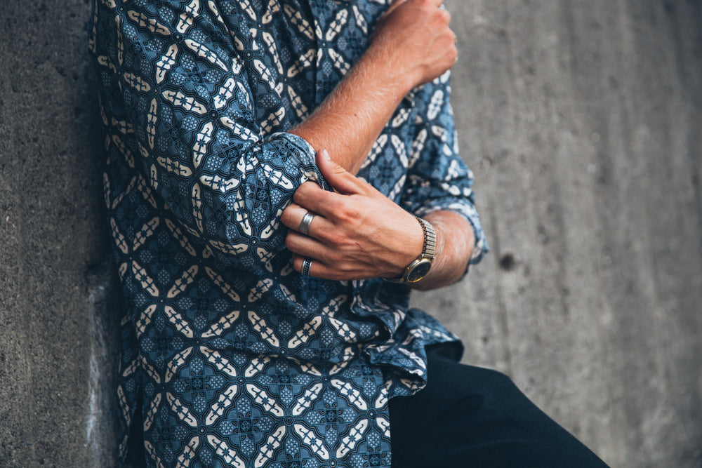 man rolls up shirt sleeves