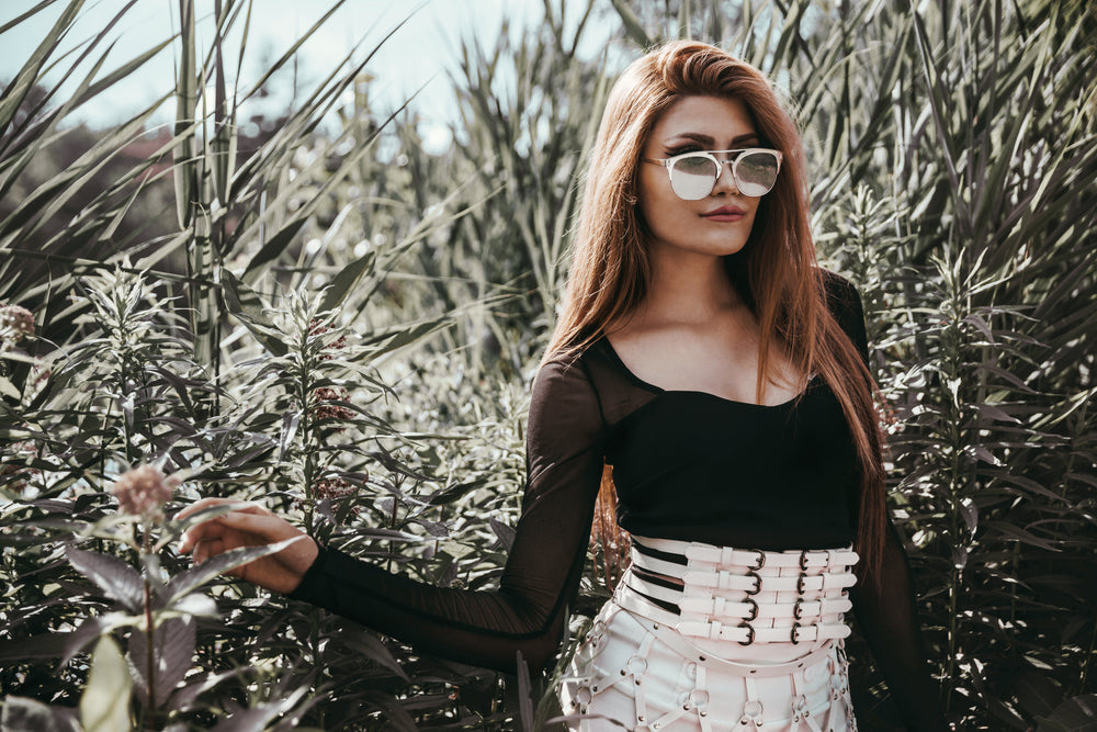 model poses near bushes