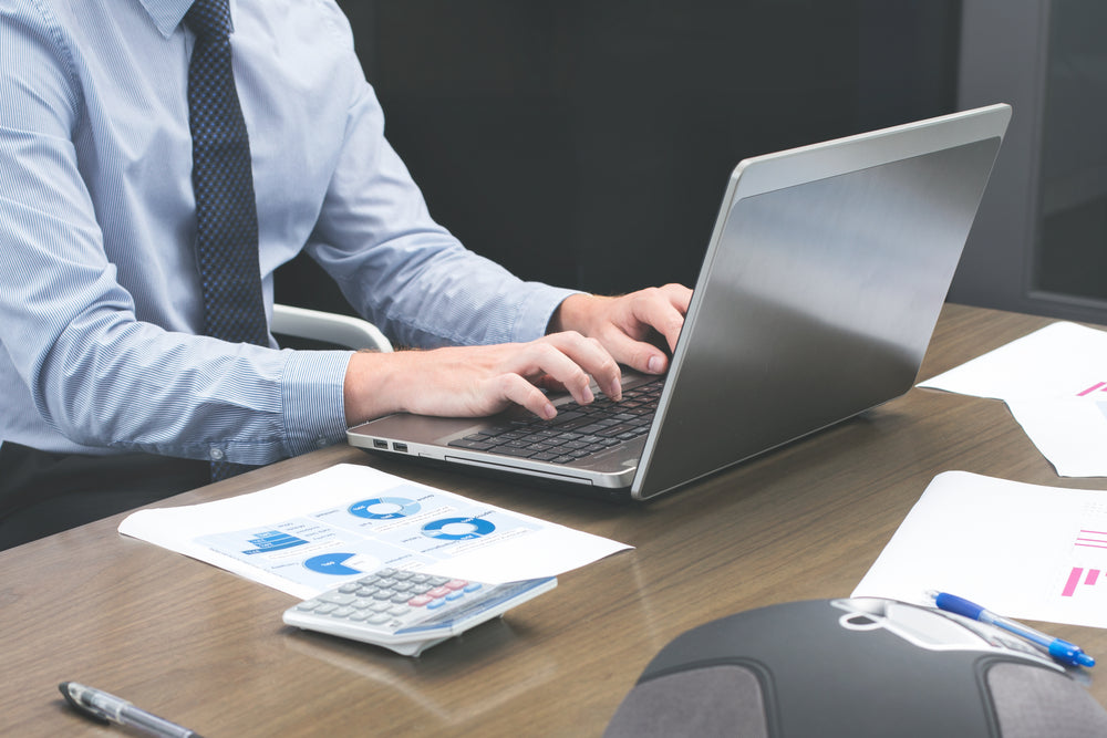 office staff typing on laptop