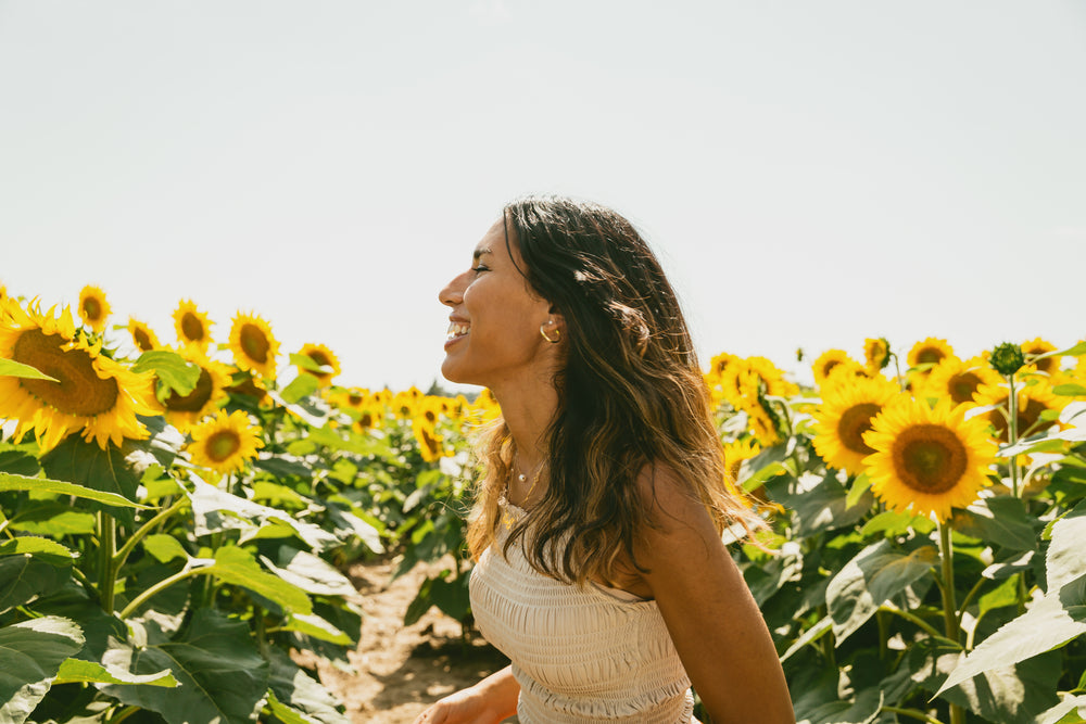 profile of a person smiling in a sunflower field