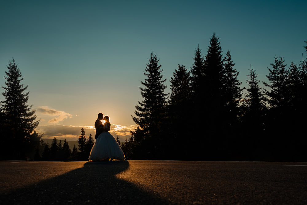 sunset silhouettes a bride and groom facing each other