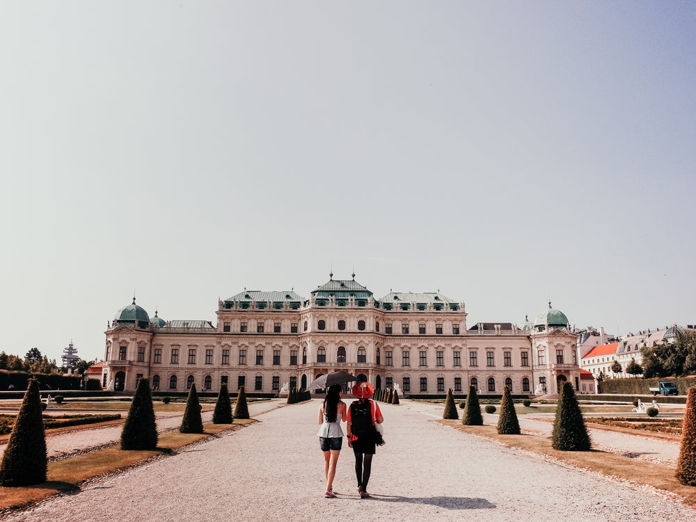 two people walk towards a large white building