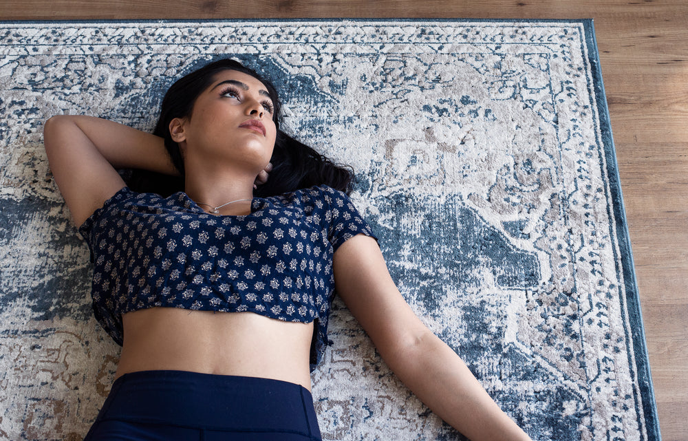 woman in blue yoga attire on blue rug