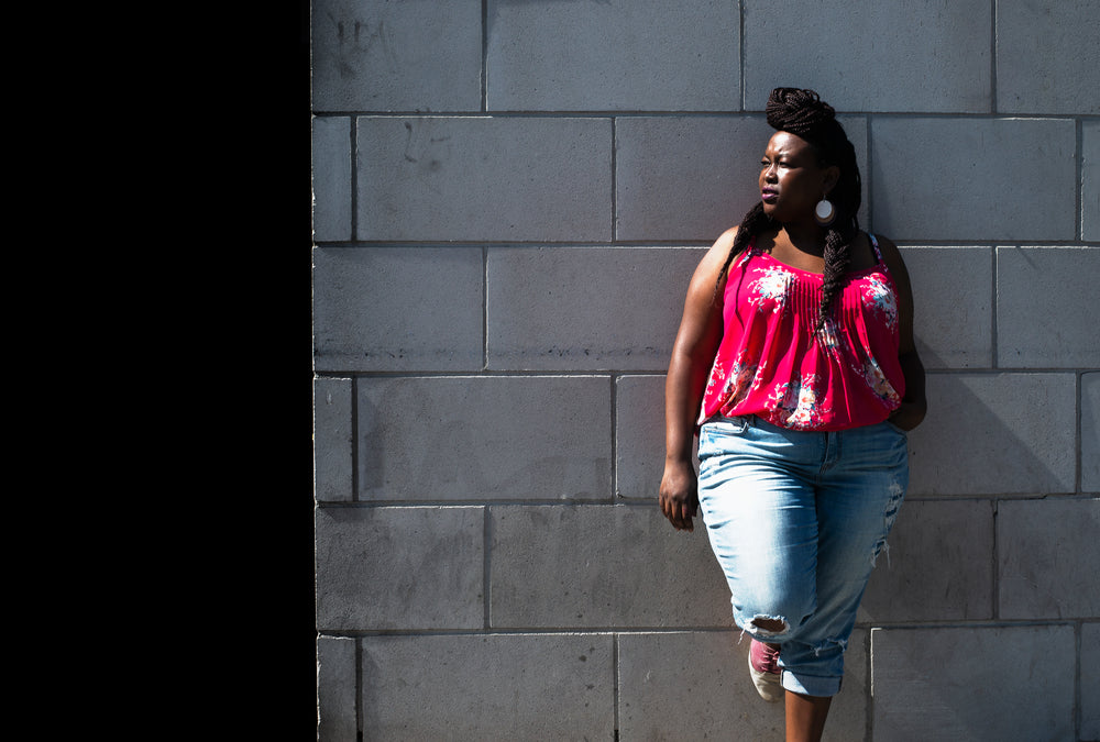 woman in summer fashion leans on wall