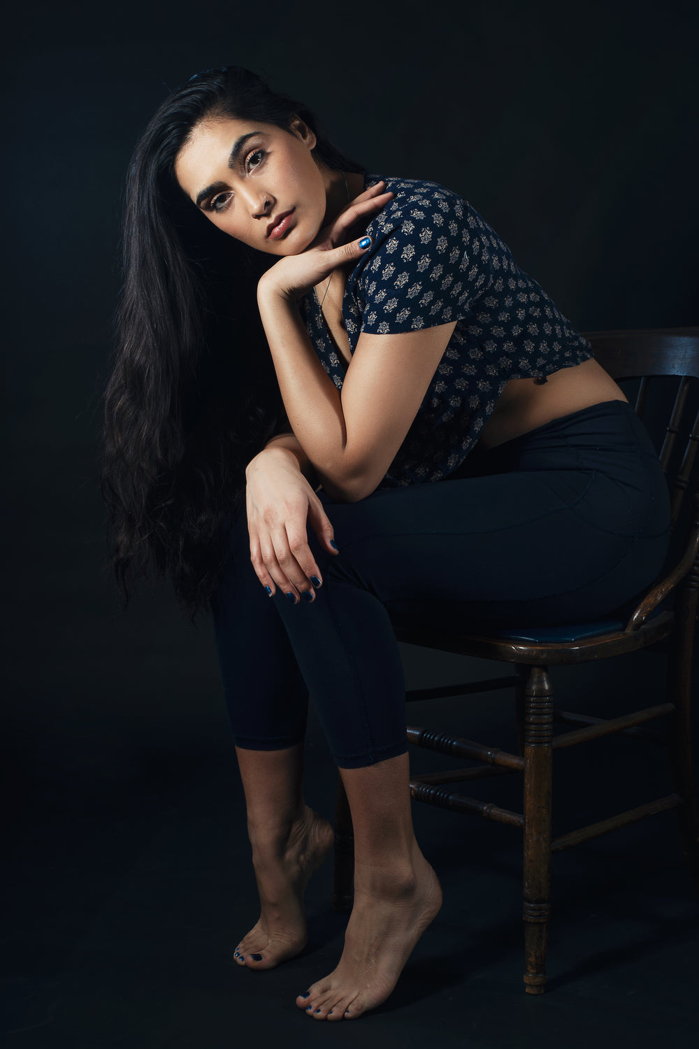 Woman Perched On Wooden Chair