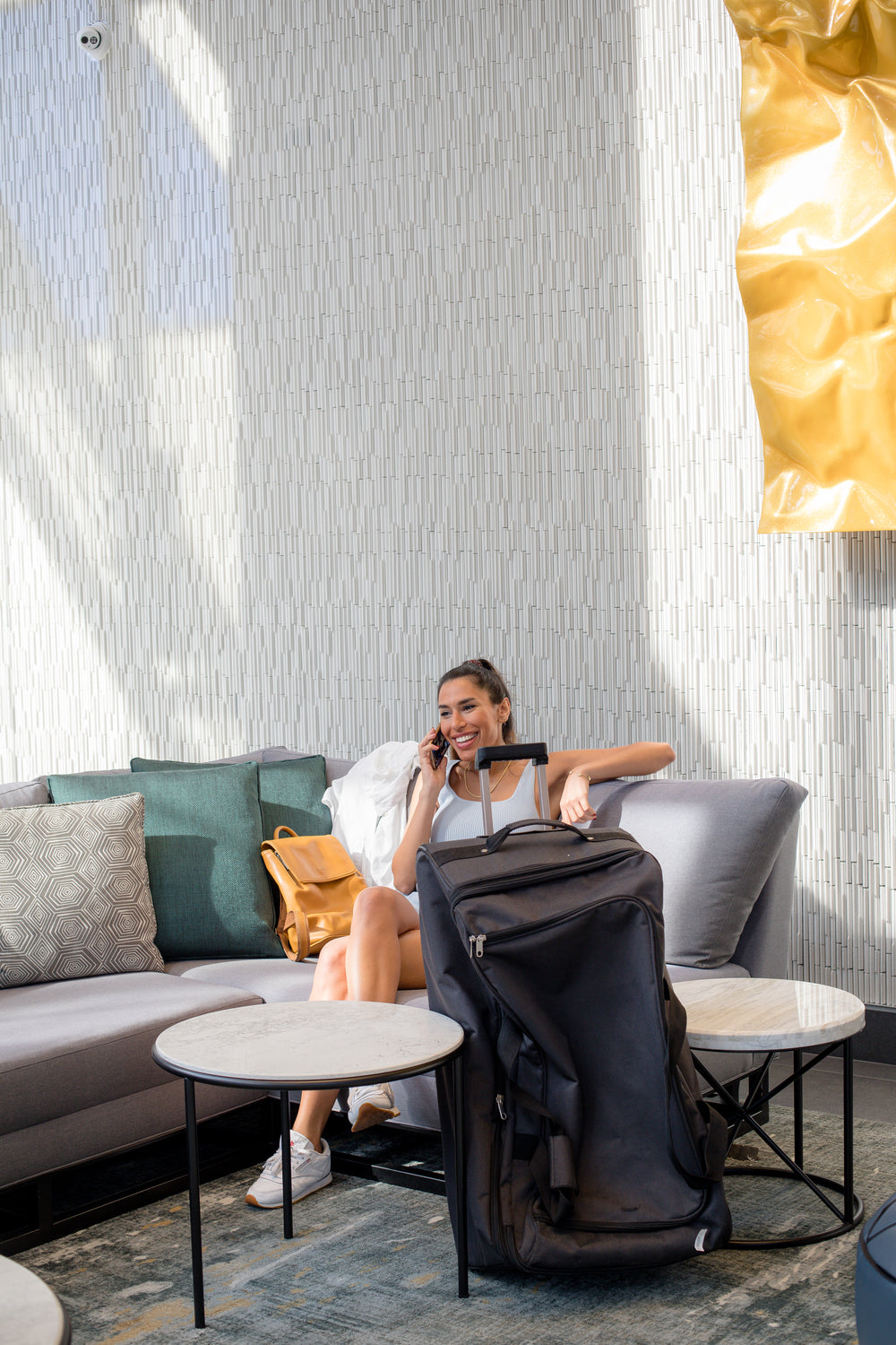 woman talks on her cell phone beside her luggage