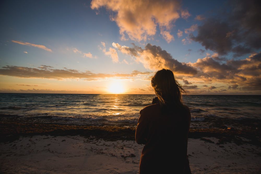 woman watching beach sunrise