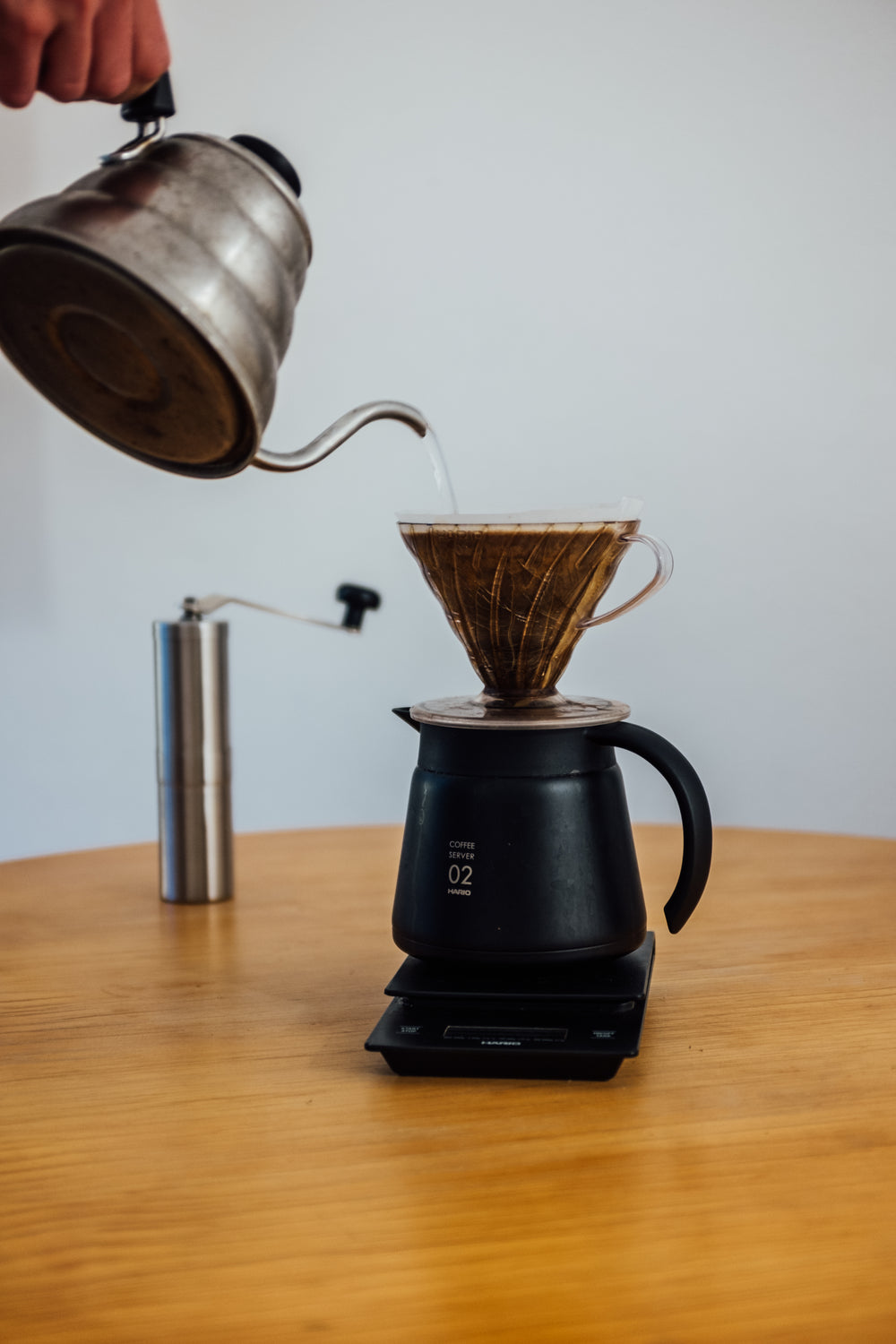 wooden table with a scale and pour over coffee