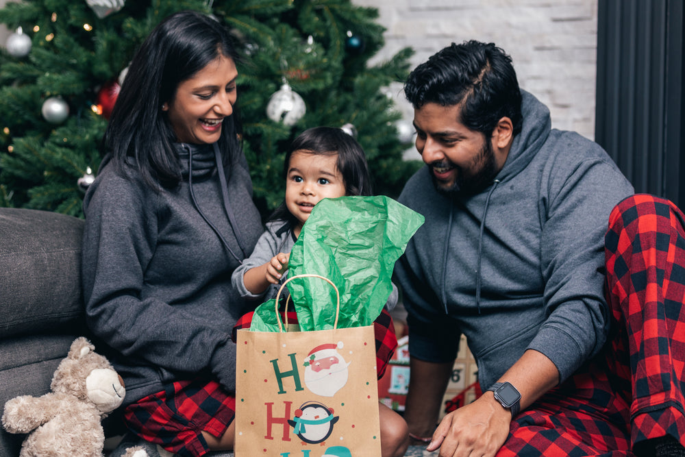 young boy happily opens christmas present