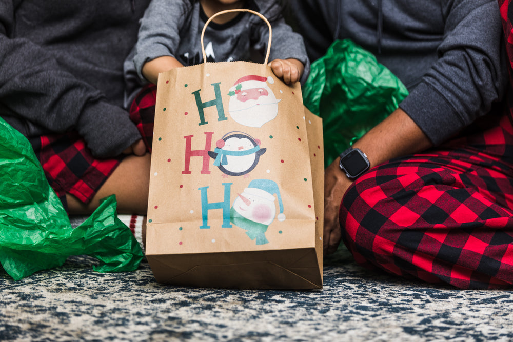 young family opens christmas gifts together